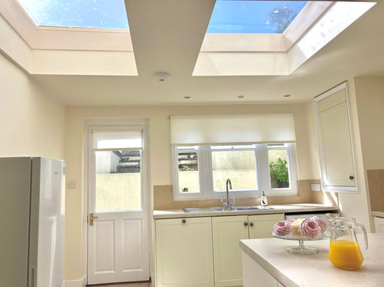 Modern kitchen with skylights, cream cabinets, donuts