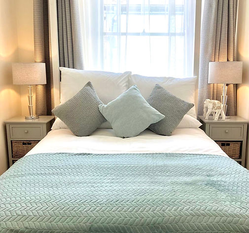 Modern bedroom with white bedding and light blue accent pillows