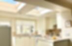 Bright kitchen with skylights, cream cabinets, and island