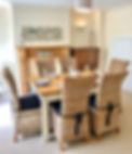 Dining room with a wooden table and wicker chairs set for six