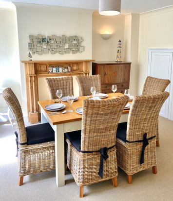 Dining room with wooden table and six wicker chairs