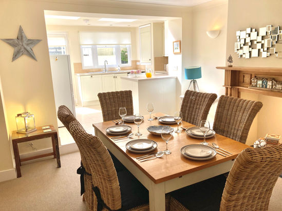 Dining room with set table and open-plan kitchen