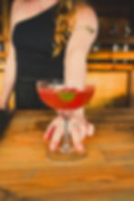 pink cocktail in glass being served