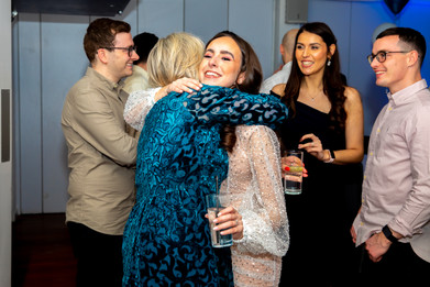 Bride to be hugs guests at her engagement party by a party photographer hertfordshire