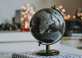 Black and gray globe sitting on a travel planner
