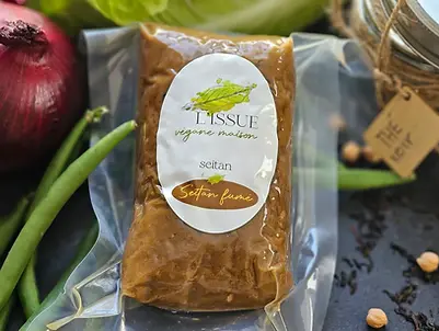 Seitan fumé à la texture ferme, présenté avec oignon rouge, haricots verts et épices.