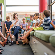 Enseignant et enfants en bibliothèque