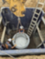 setting large tank in ground with shoring, equipment and laborer