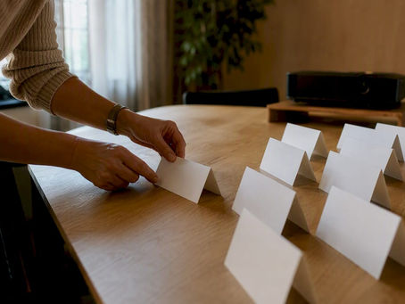 Hands arranging name placards on table