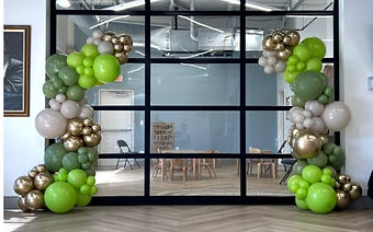 Green and gold standing garlands framing a glass wall