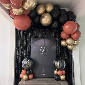 Terracotta, gold and black garland framing a welcome sign