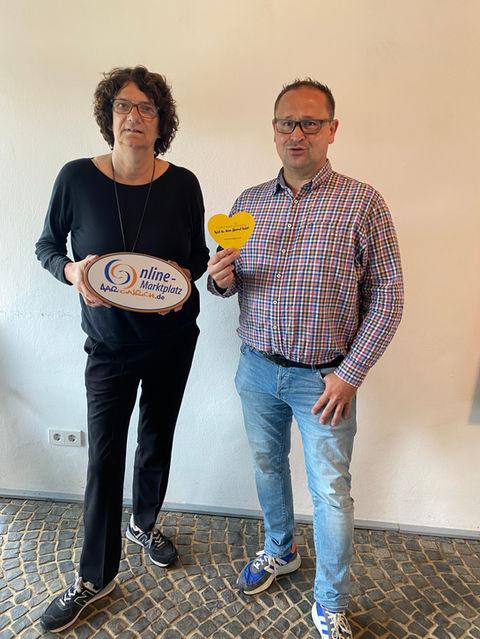Christopher Kahl und Katja Peteratzinger mit dem Powerregionen-Herz und dem Sign des Online-Marktplatzes Aar-Einrich in Gnadenthal.