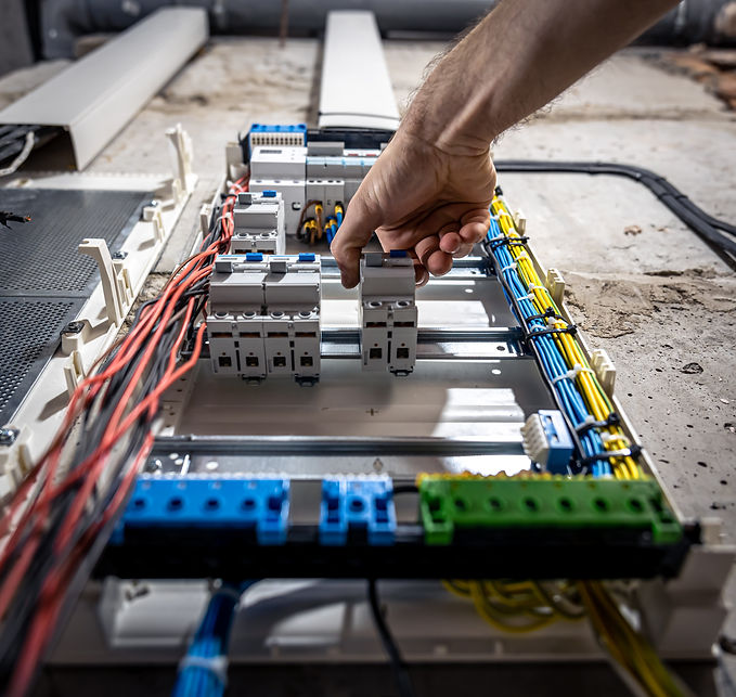 a-male-electrician-works-in-a-switchboard-with-an-2023-11-27-05-35-34-utc.jpg