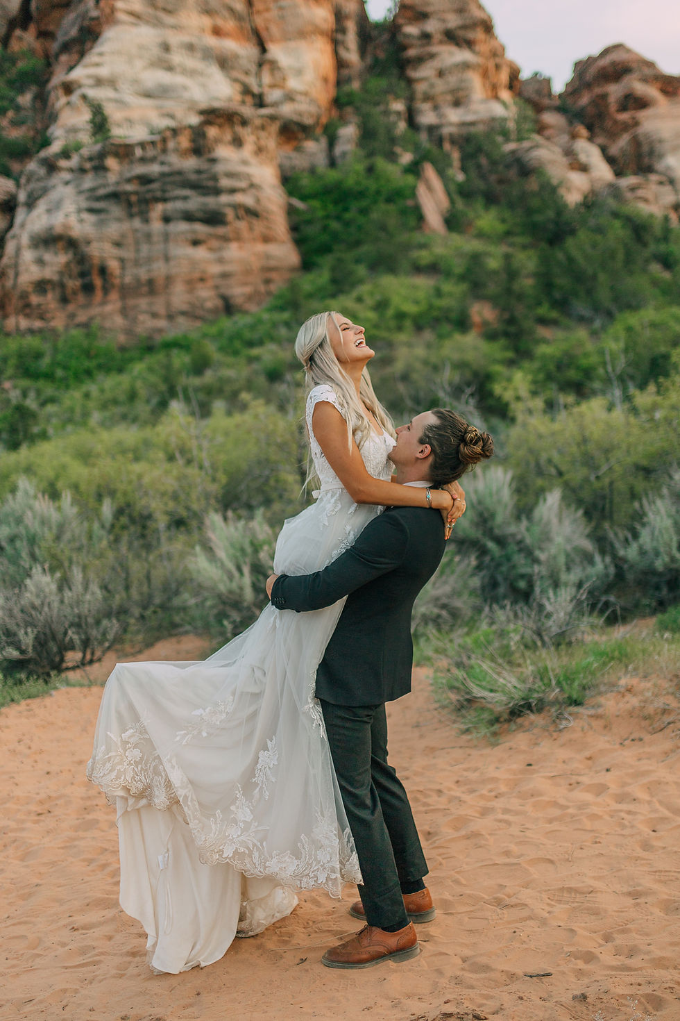 Bride and Groom dancing in the desert for their outdoor wedding in Southern Utah in their wedding dress and wedding suit. #bride #groom #utahwedding #weddingphotography #couplephotography #weddingplanner #destinationwedding #eventplanner #outdoorwedding #weddingdress #justmarried