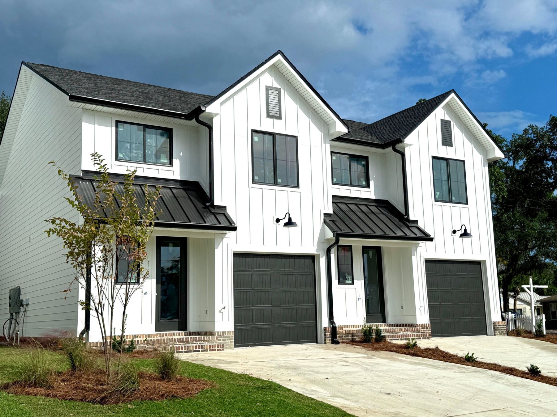 Marina Bay townhomes with white board-and-batten siding and garages