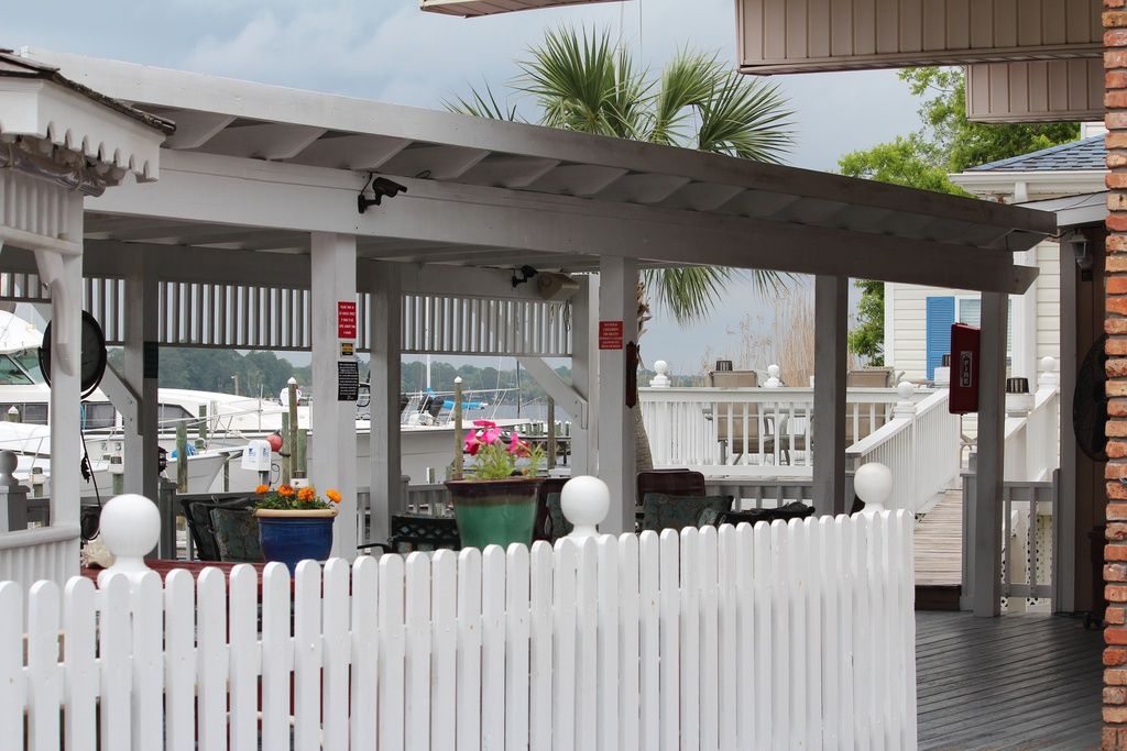 Covered seating area with flowers, overlooking the marina