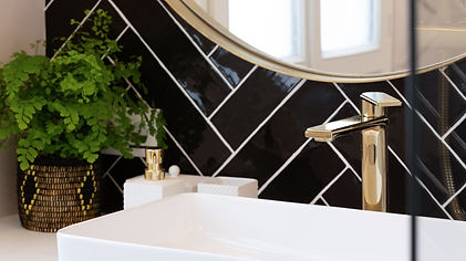 Rénovation Paris : Salle de bain art déco avec des carreaux noirs et des touches de laiton.