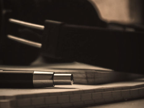 Unos auriculares sobre un cuaderno y junto a un bolígrafo.