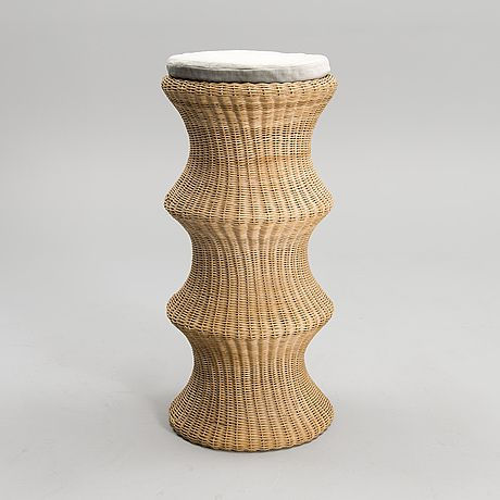 Gaze natural rattan stool by Balquire, featuring a sculptural totemic silhouette with an undulating triple-swell frame, dense artisanal wicker weaving, and a white circular seat cushion.