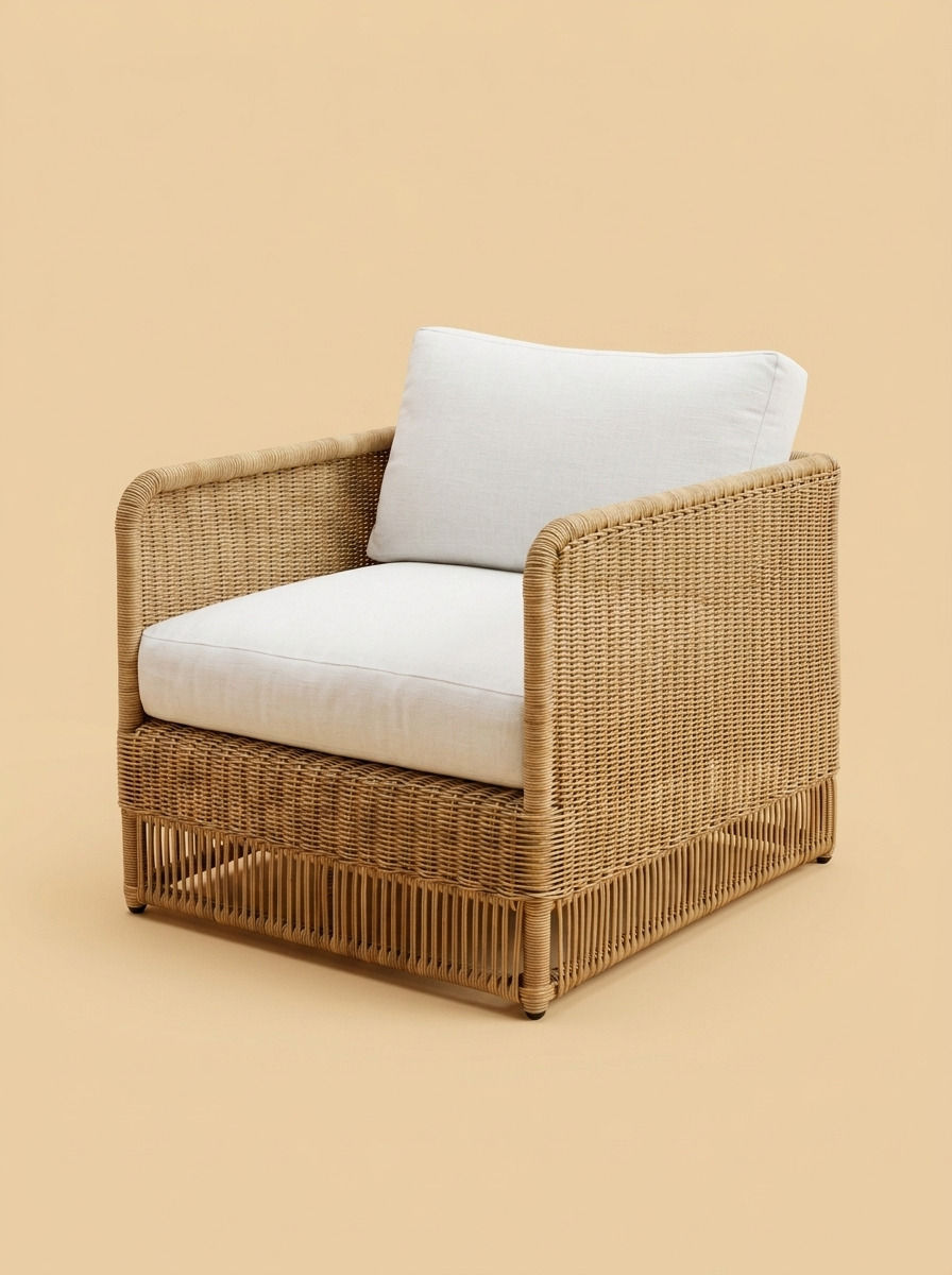 Rumi box-style lounge chair by Balquire, featuring a full fine-knit rattan weave in honey tones, a slatted open base, and plush white linen cushions, shown in a minimalist studio setting.