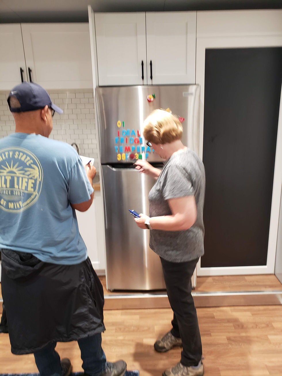 A couple interacts with a piece of refrigerator magnet gameplay