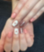 Pink and white manicure with glitter and heart nail art.
