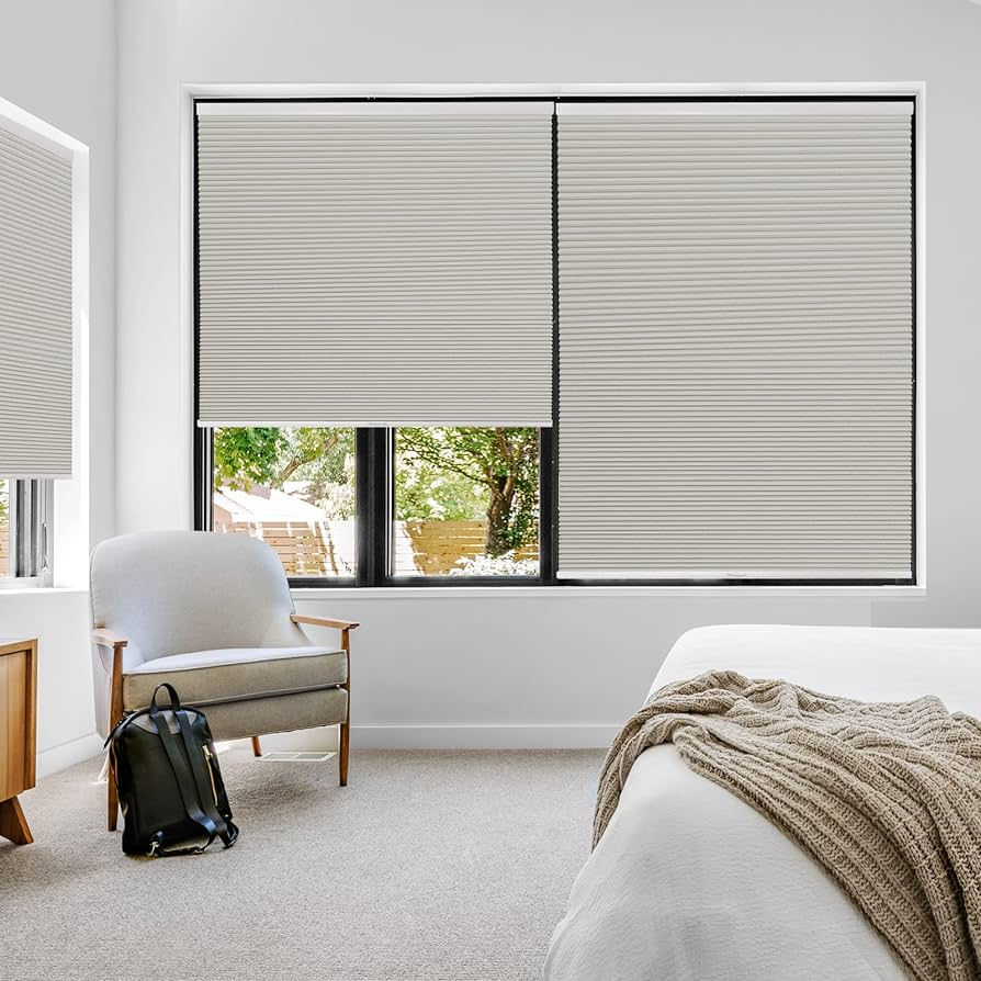 Eye-level view of a well-lit room with honeycomb blinds partially open