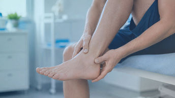 Persona sujetándose el tobillo por dolor, en una guía sobre las causas del dolor de tobillo.