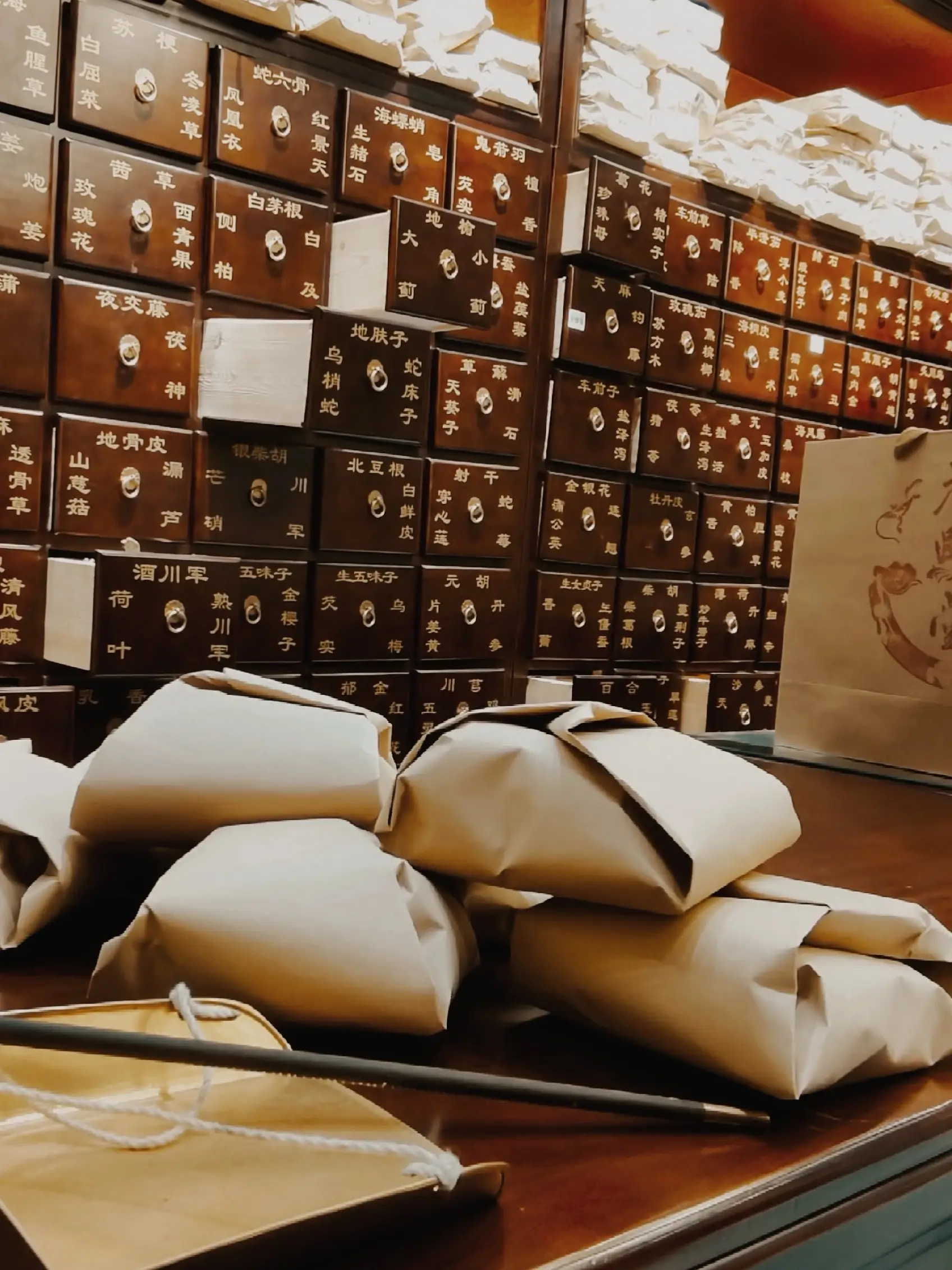 Traditional Chinese herbal medicine drawers and packaged herbs displayed in a Beijing TCM pharmacy