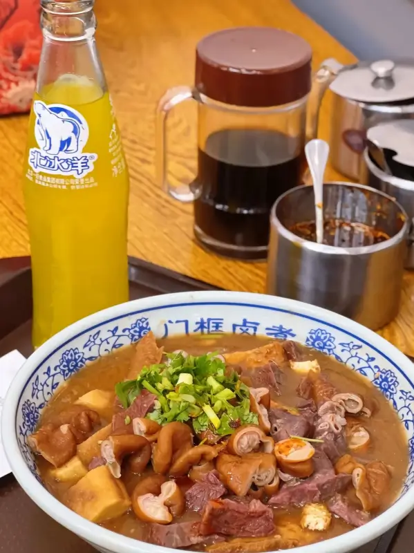 Luzhu huoshao served with broth and tofu pieces in a traditional bowl