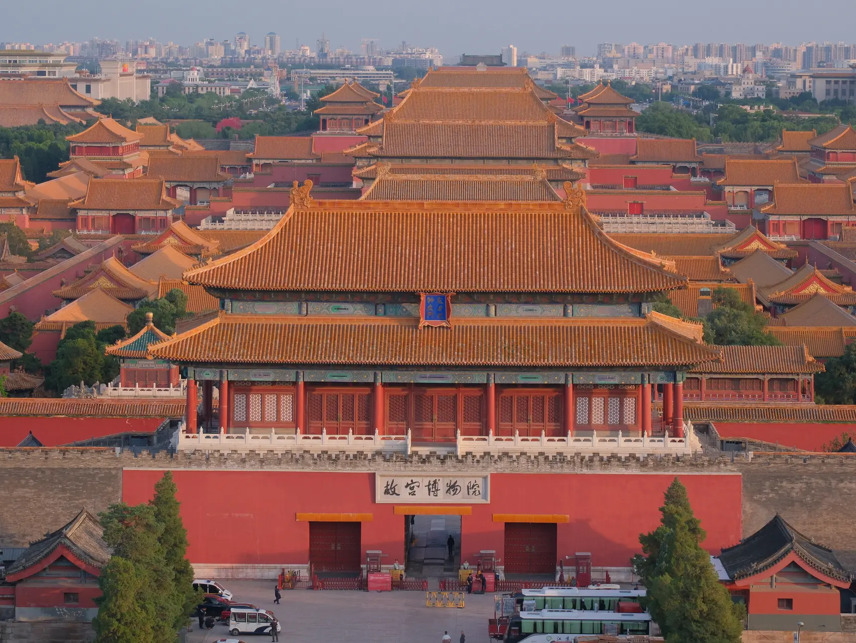 View of the Forbidden City from Jingshan Park in Beijing, showing the golden palace rooftops and historic central axis of the old city.