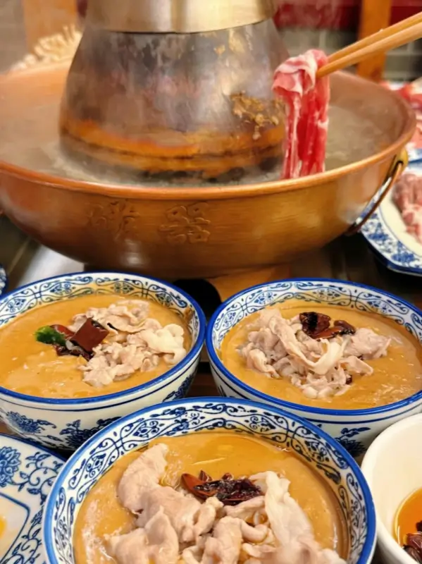 Beijing style shuanyangrou cooked in a copper hotpot with dipping sauces