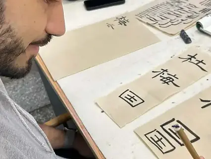 Creating a final Chinese calligraphy artwork on rice paper.