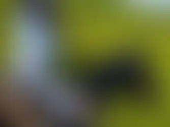 Woman horseback riding across open green grasslands near Beijing, wearing a wide-brim hat and riding a black horse along scenic countryside trails