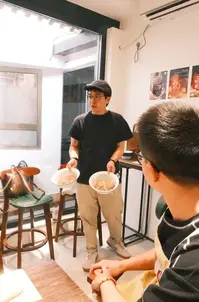 Local instructor introducing traditional Chinese bun fillings during Bite Escape's Hutong Bun Making Experience, sharing food culture and cooking techniques in a cozy Beijing courtyard setting.