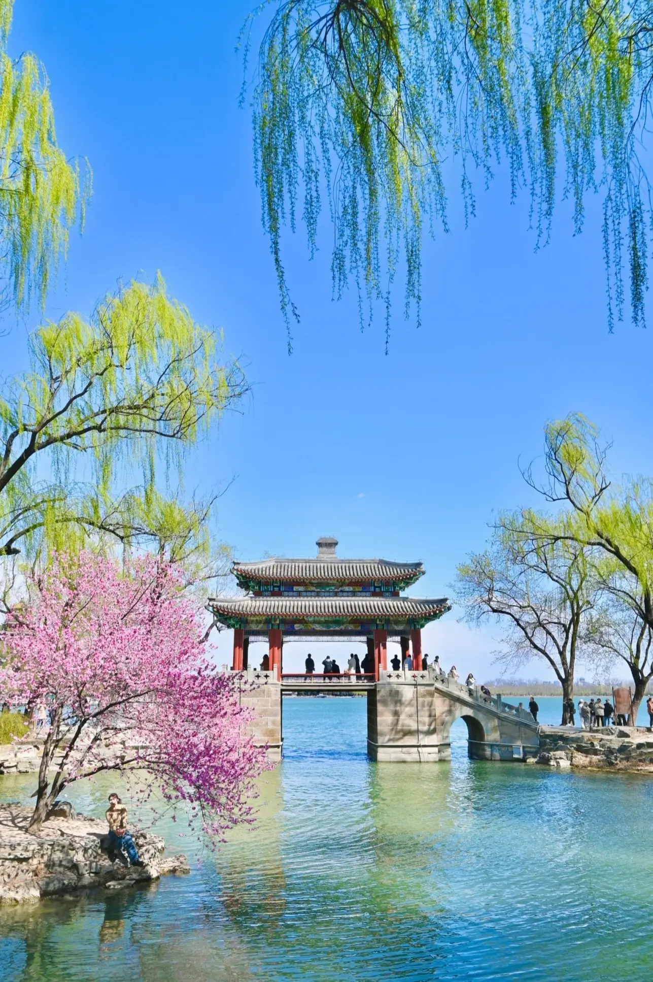Spring blossoms and weeping willows by a traditional Chinese pavilion at the Summer Palace in Beijing.
