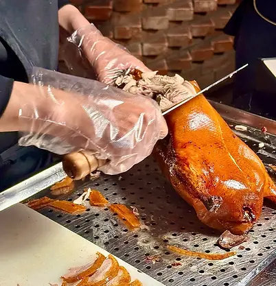 Peking duck being sliced by chef in Beijing, iconic local food experience on private tours