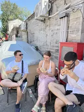 Travellers eating Beijing street snacks in a local alley