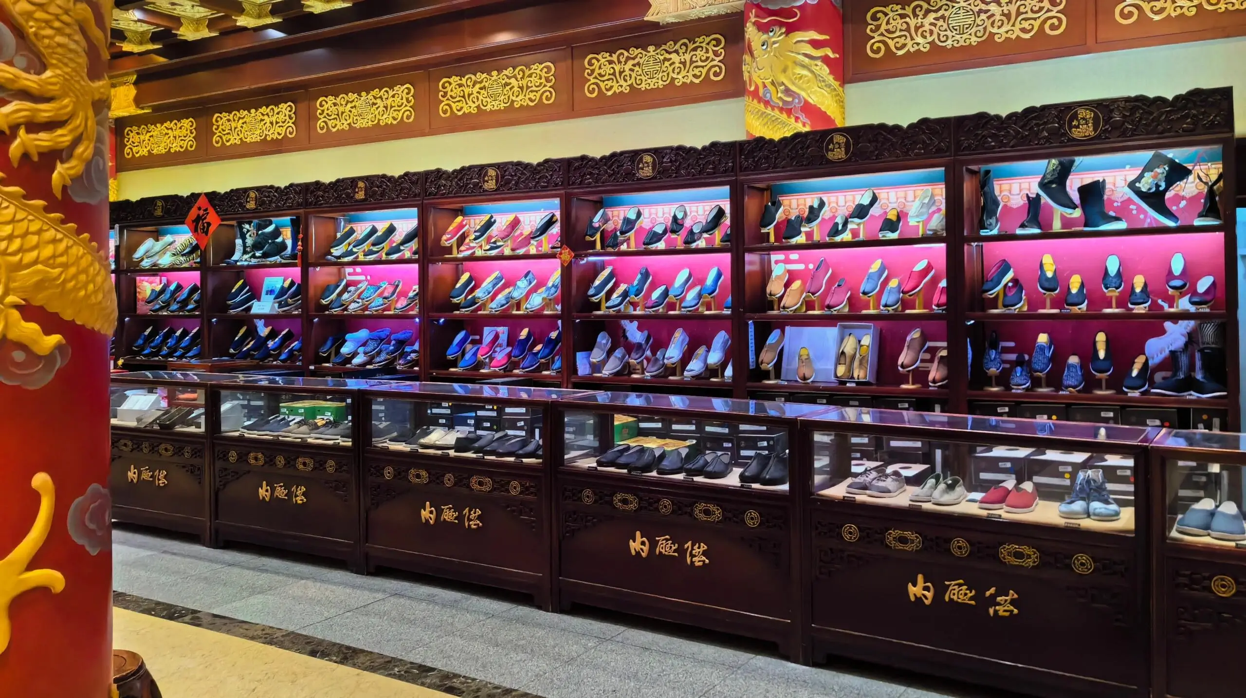 Interior of Neiliansheng store displaying rows of traditional Beijing cloth shoes in a classic wooden showcase.