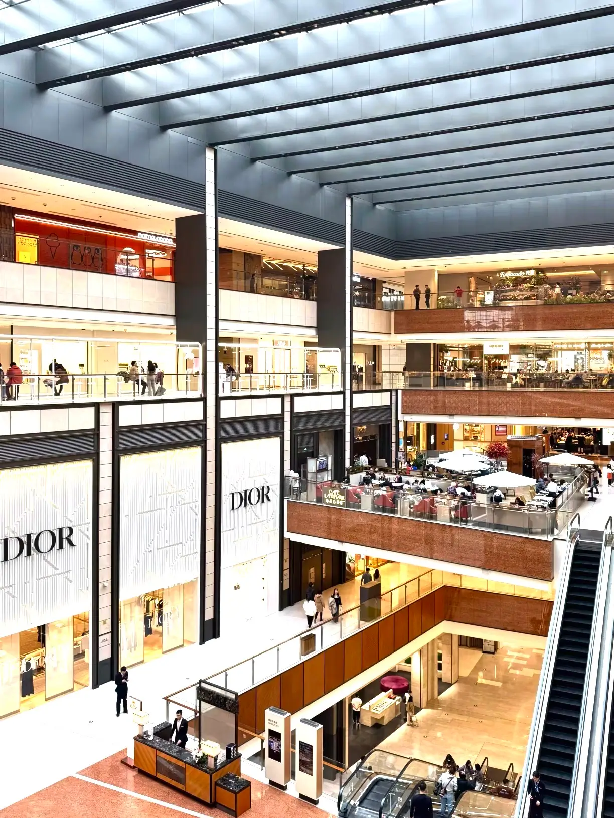 Spacious interior of China World Mall in Beijing with Dior boutiques and multiple floors of luxury retail, showcasing premium Beijing shopping in the CBD area.