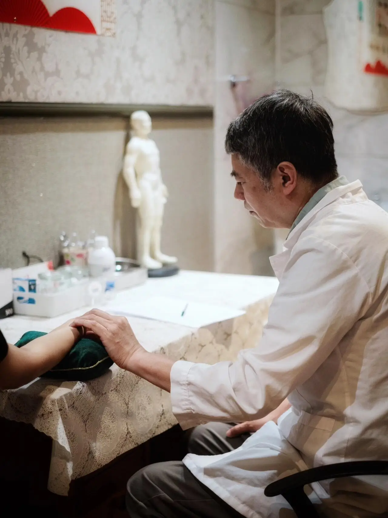 Traditional Chinese Medicine practitioner performing pulse diagnosis during a TCM consultation in Beijing