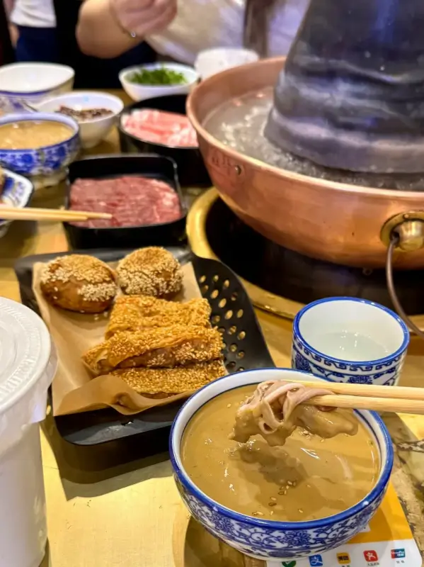 Mutton Hotpot copper pot setup with sesame flatbread and snacks.