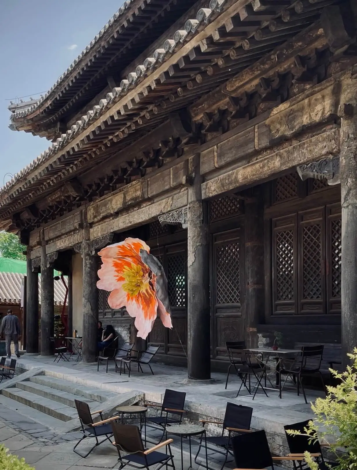 Traditional Chinese temple architecture courtyard with wooden halls and outdoor seating