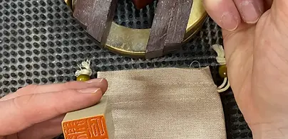 Carving a personalized Chinese stone seal during a workshop in a Beijing hutong studio.