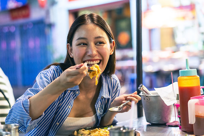 Young Asian woman traveler tourist eating Thai street food in China town night market in B