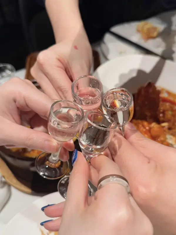 people saying ganbei with baijiu at a chinese banquet