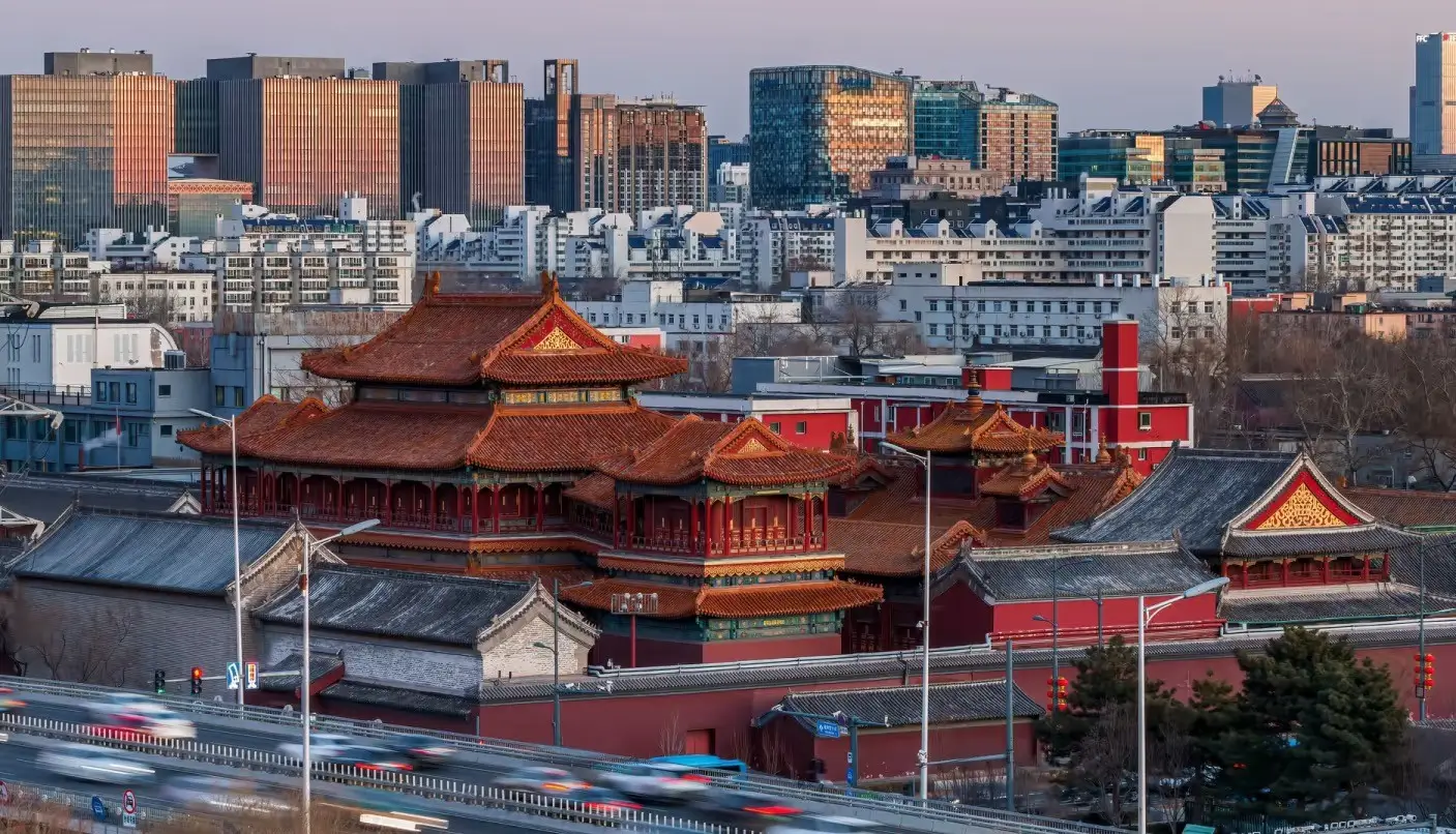 Traditional red palace architecture of Beijing set against a modern city skyline