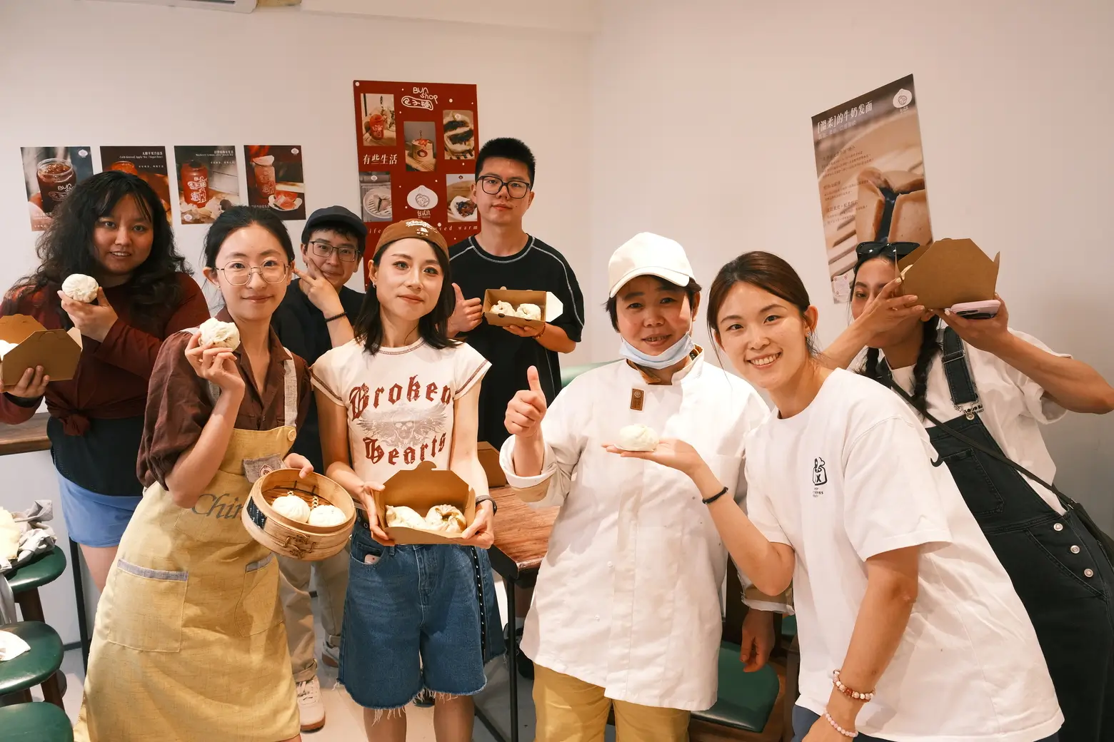 Travelers and local hosts holding freshly made buns during a Bite Escape hutong bun-making experience in Beijing