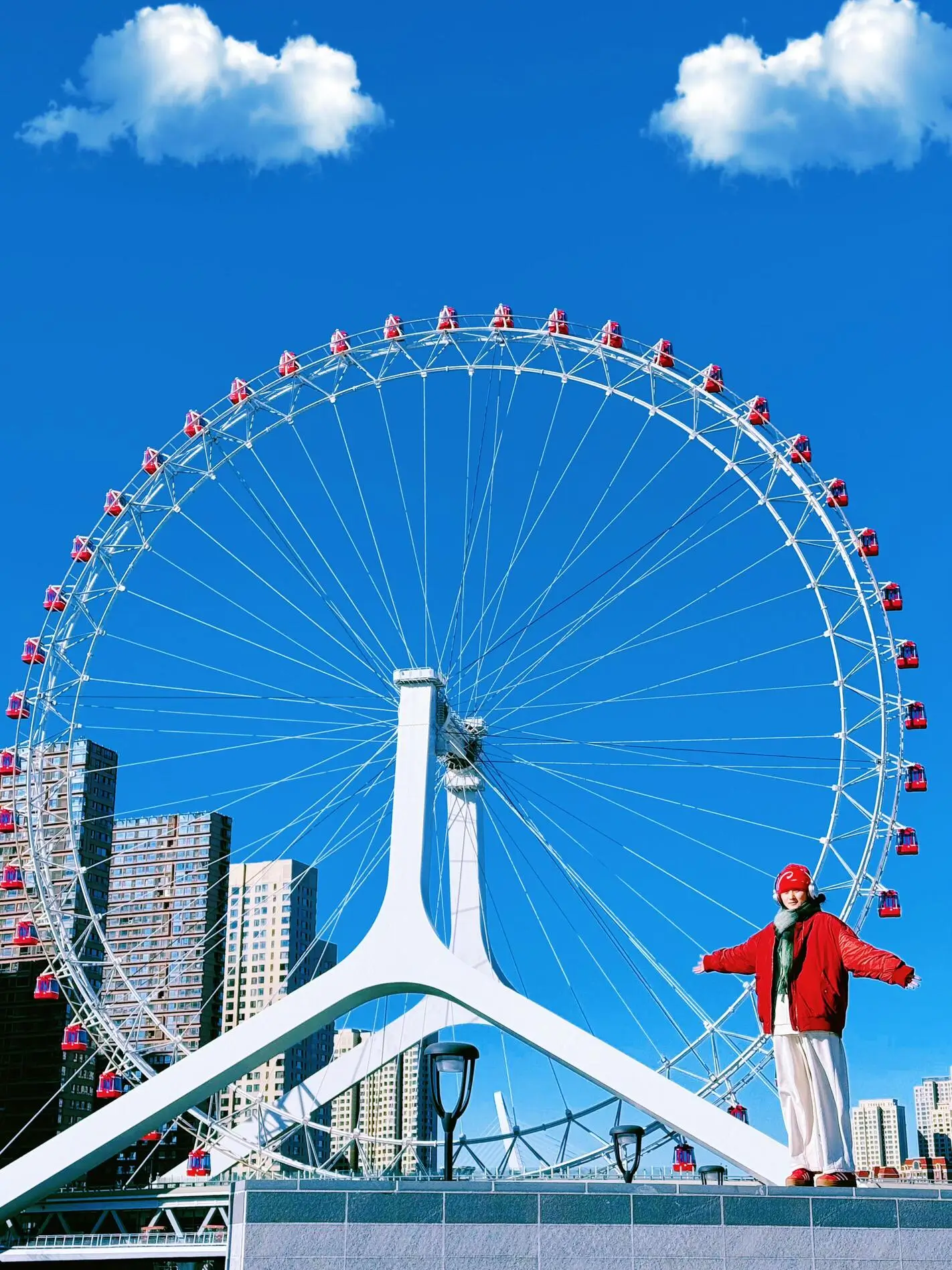 Close-up view of Tianjin Eye Ferris wheel with colorful cabins against a blue sky, showcasing Tianjin’s famous riverside landmark