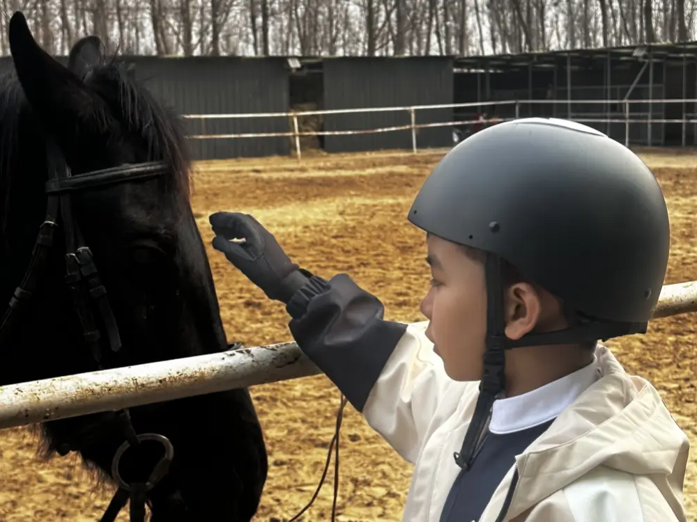 Child interacting with a horse during a Bite Escape horseback experience in Beijing